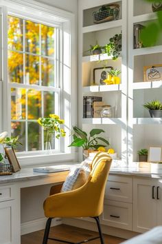 a yellow chair sitting in front of a window next to a desk with plants on it