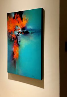 an abstract painting hangs on the wall