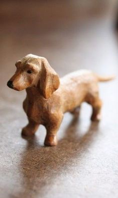 a small toy dog standing on top of a wooden floor