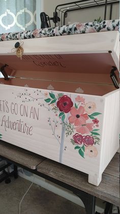 a painted wooden box sitting on top of a bench with the words let's go on an adventure