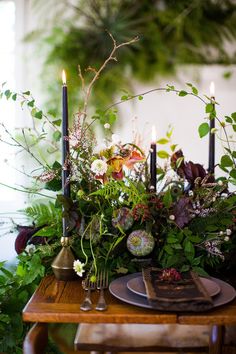 a table topped with lots of flowers and candles