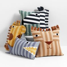 four pillows with different designs on them sitting next to each other in front of a white wall