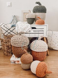 knitted pumpkins sitting on top of a white table in front of a basket