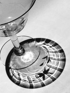 a wine glass sitting on top of a table next to a plate with an object in it