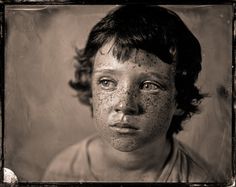 an old photo of a young boy with freckles on his face and eyes