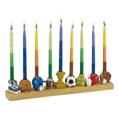 a group of candles that are sitting on a table with balls and shoes in front of them