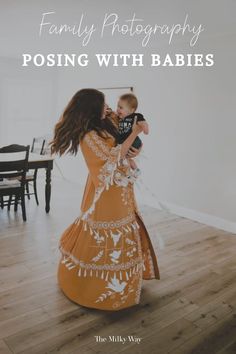 a woman in an orange dress holding a baby