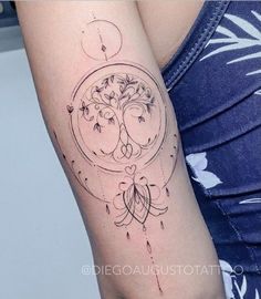 a woman's arm with a tattoo on it and a tree in the center