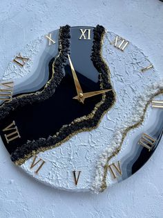 a black and gold clock with roman numerals