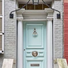 a light blue door is in front of a brick building