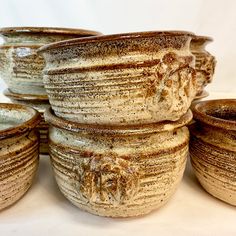 a group of ceramic bowls sitting next to each other on top of a white table