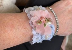 Handgefertigtes Shabby Chic Lace Denim Armreif ~ 3 Zoll Hergestellt aus einem Denim-Bund mit Pailletten-Spitzenbesatz, Pfirsich Kunstblume aus Organza Befestigt ein Vintage-Knopf und Kunstlederband zum einfachen Anbringen Perfekt für eine Hochzeit, Abschlussball oder einfach nur für die Nacht in Jeans Tolle Geschenkidee! Denim Cuff Bracelet, Lace Cuff Bracelet, Fabric Cuff Bracelet, Lace Cuffs, Denim Chic, Fabric Cuff, Denim And Lace, Vintage Button, Faux Flowers