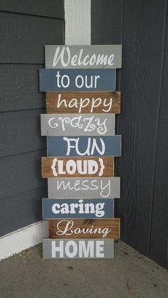 a wooden sign that says welcome to our happy crazy fun loud messy caring raising home