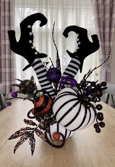 a table topped with halloween decorations on top of a wooden table next to a window