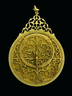 an ornate gold pendant with filigrees on it