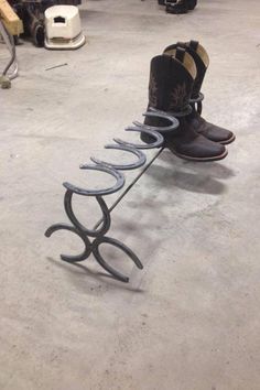 a pair of boots sitting on top of a metal shoe rack in a garage area