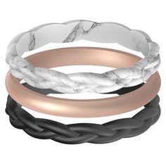 three different colored rings with black, white and rose gold bands on each one side