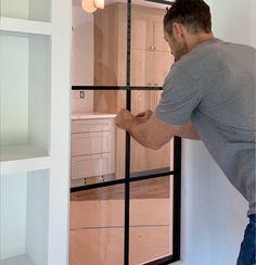 a man standing in front of a sliding glass door looking at the inside of his house