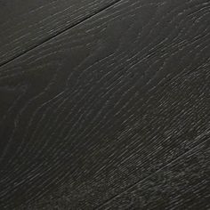 a close up view of the wood grains on this flooring material, which looks like it has been painted black