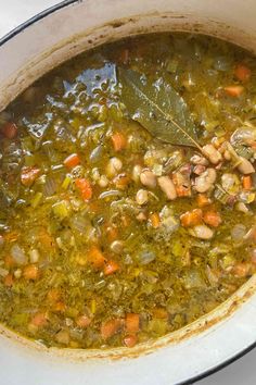 a pot filled with soup and vegetables on top of a table