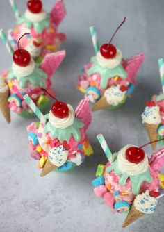 ice cream sundaes with cherries and sprinkles are arranged in small cones