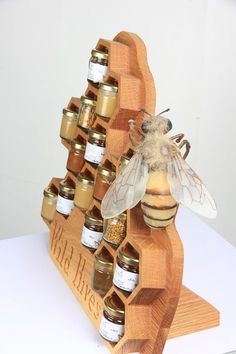 a wooden rack with honey jars and a bee sitting on it's back legs