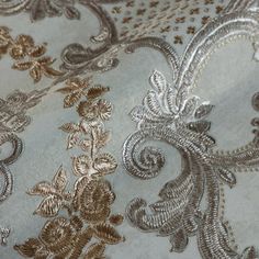 the fabric has gold and silver designs on it's side, as well as an intricate