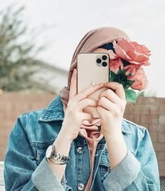 a woman taking a selfie with her phone and flowers in front of her face