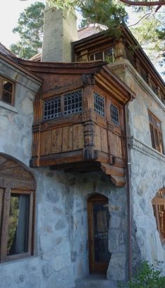 an old stone building with wooden balconies and windows on the top floor is shown