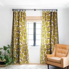 a chair sitting in front of a window next to a potted plant