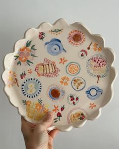 a hand holding a plate with many different designs on it