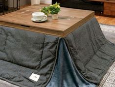 a coffee table with a blanket on it in a living room next to a couch