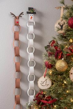 two christmas ornaments are hanging on the wall next to a christmas tree with other decorations