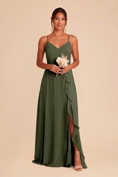 a woman wearing a green dress with a flower in her hand and holding a bouquet