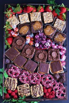 an assortment of desserts and pastries arranged on a platter with strawberries