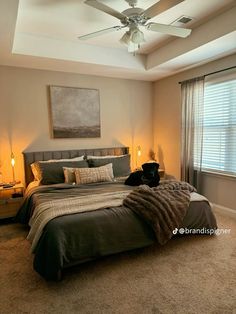 a bedroom with a large bed and ceiling fan