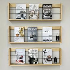 three wooden shelves with books on them in the middle and one shelf is filled with magazines