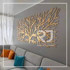 a living room with couches and a large metal tree wall art on the wall