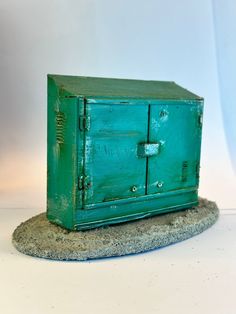 a green cabinet sitting on top of a rock