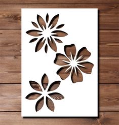 three paper flowers on a wooden surface