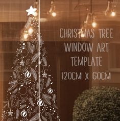 a christmas tree window art template in front of a storefront with lights and ornaments