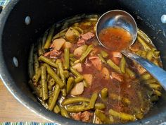 a pot filled with green beans and meat