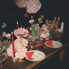 the table is set with pink flowers and candles