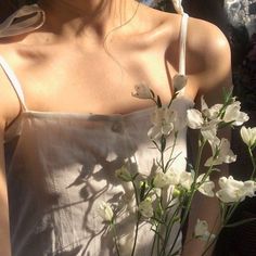 a woman wearing a white dress holding flowers