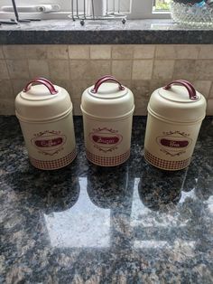 three white containers sitting on top of a counter