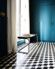 there is a black and white checkered floor with blue cabinets in the background,