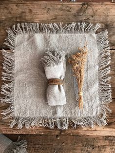 the table is set with two napkins and some dried flowers