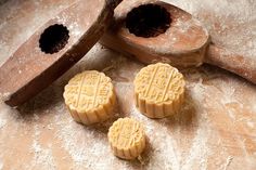 three mooncakes sitting on top of a table next to a wooden spoon