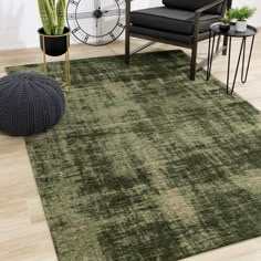 a living room area with a green rug, chair and clock on the wall behind it