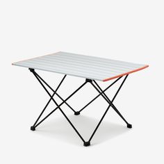 a white table with an orange top and black legs on it's side, against a white background